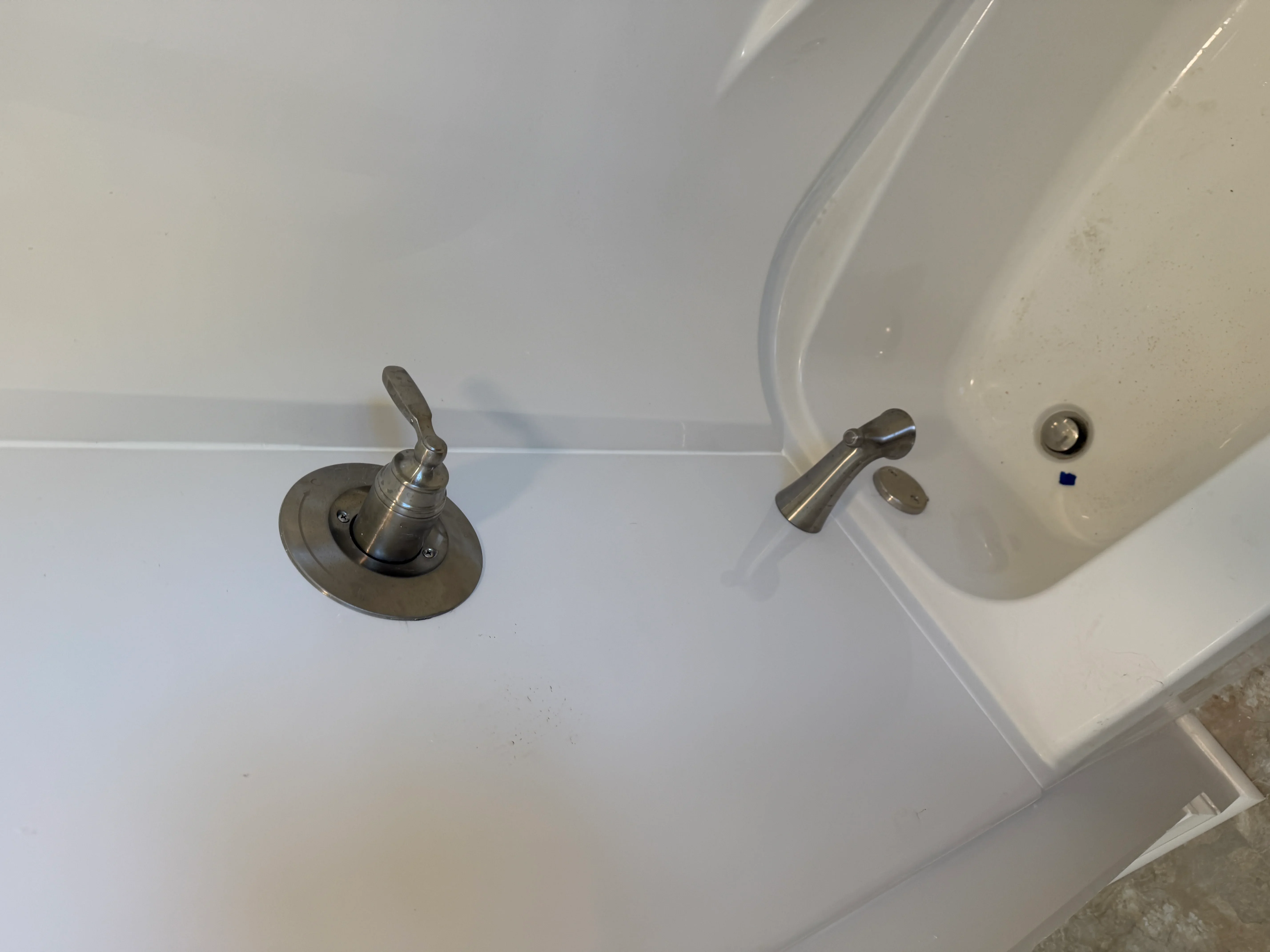 Brushed nickel faucet and white ceramic sink basin installation with single-handle lever